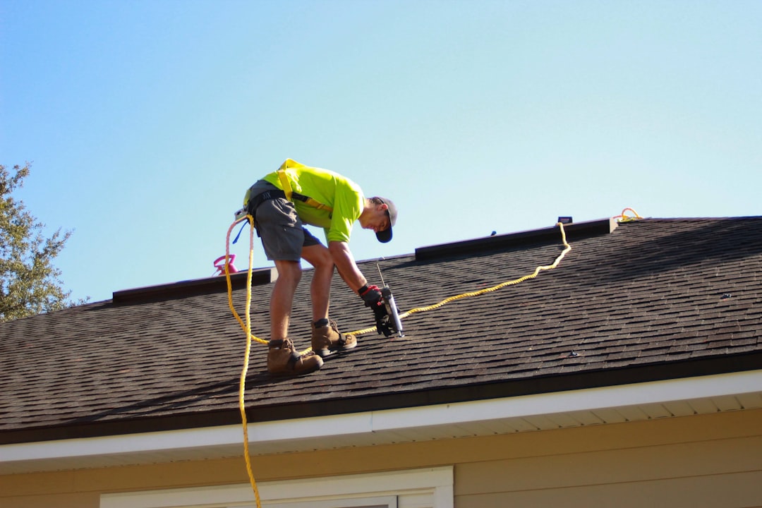 Service a-man-working-on-a-roof-with-a-power-drill-scaj0t40nfi